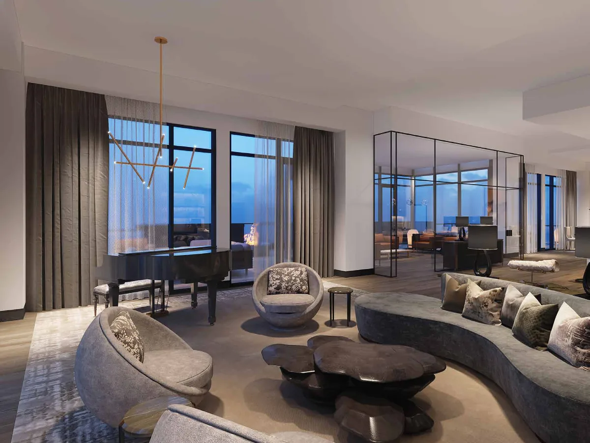 Open-plan lounge with curved seating in front of a full-height glazed wall of large sliding panels overlooking water.