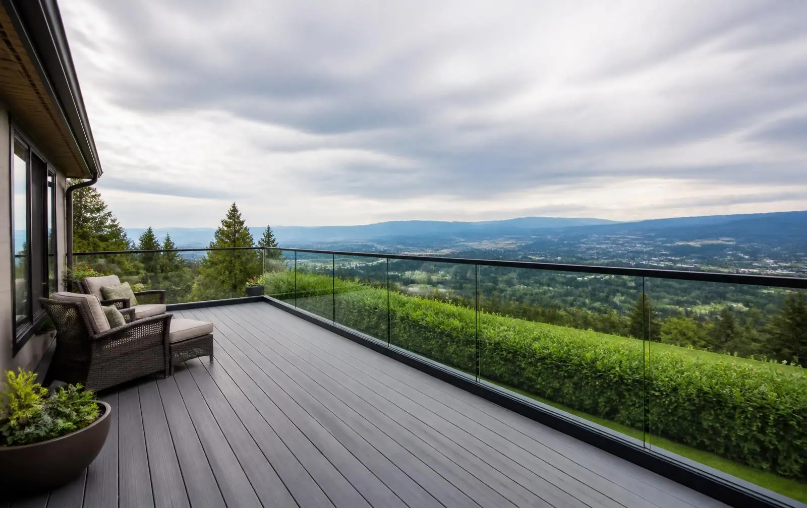 Design reference: a renovated deck with a clear frameless glass railing opening the same valley view