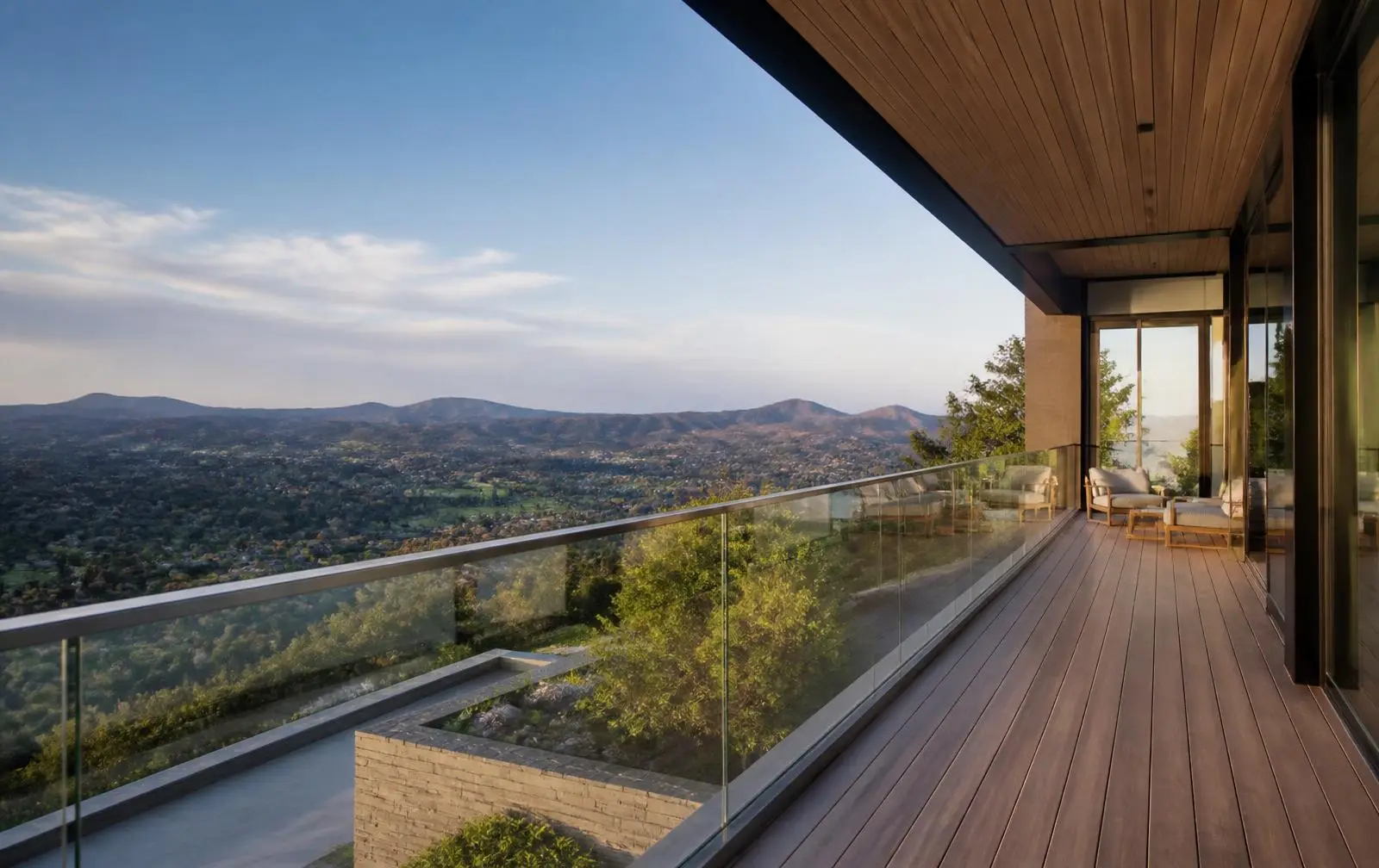 Design reference: a hillside balcony with a frameless structural glass balustrade overlooking a green valley