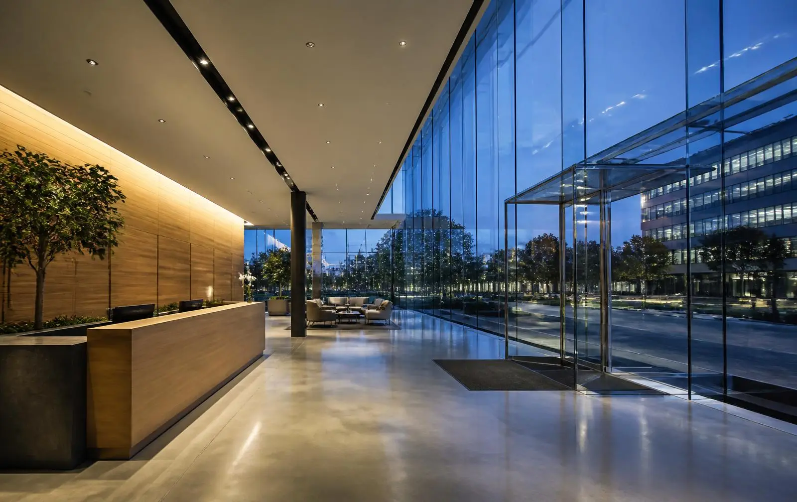 Design reference: commercial lobby entrance framed by frameless glass doors and full-height glazing
